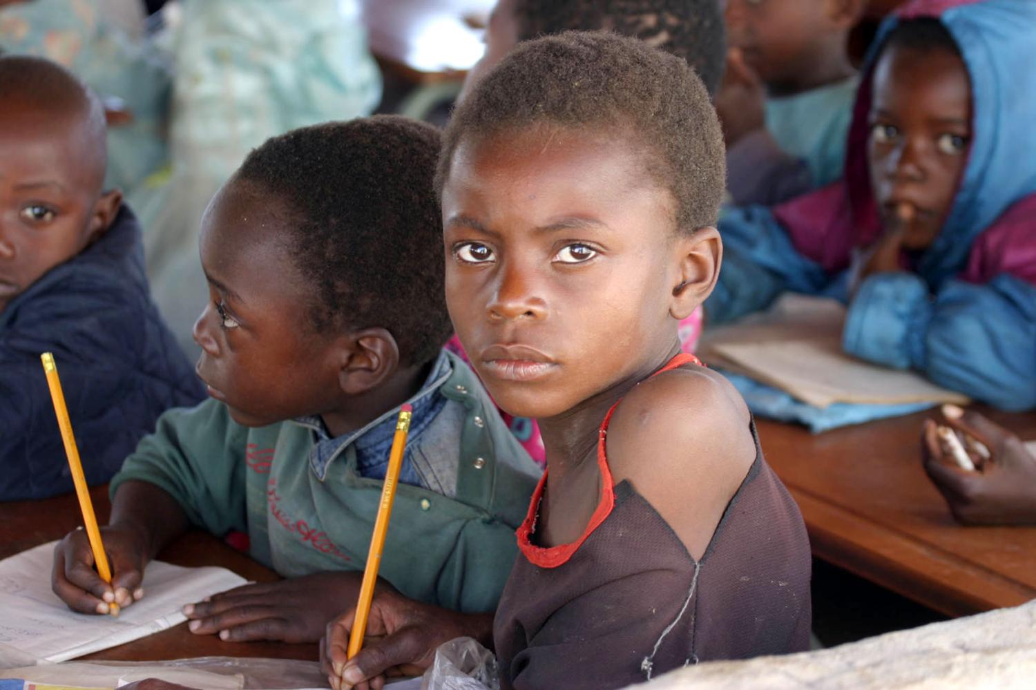 Zambian children attend school in a poverty stricken area near the country's capital Lusaka July 1, 2005. July 1 was designated "Whit Band Day" as campaigners began a week of action aimed at focusing attention on issues of poverty ahead of next weeks meeting of G8 leaders in Gleneagles, Scotland. REUTERS/Salim Henry  SH/AH - RP6DRMVDHNAB