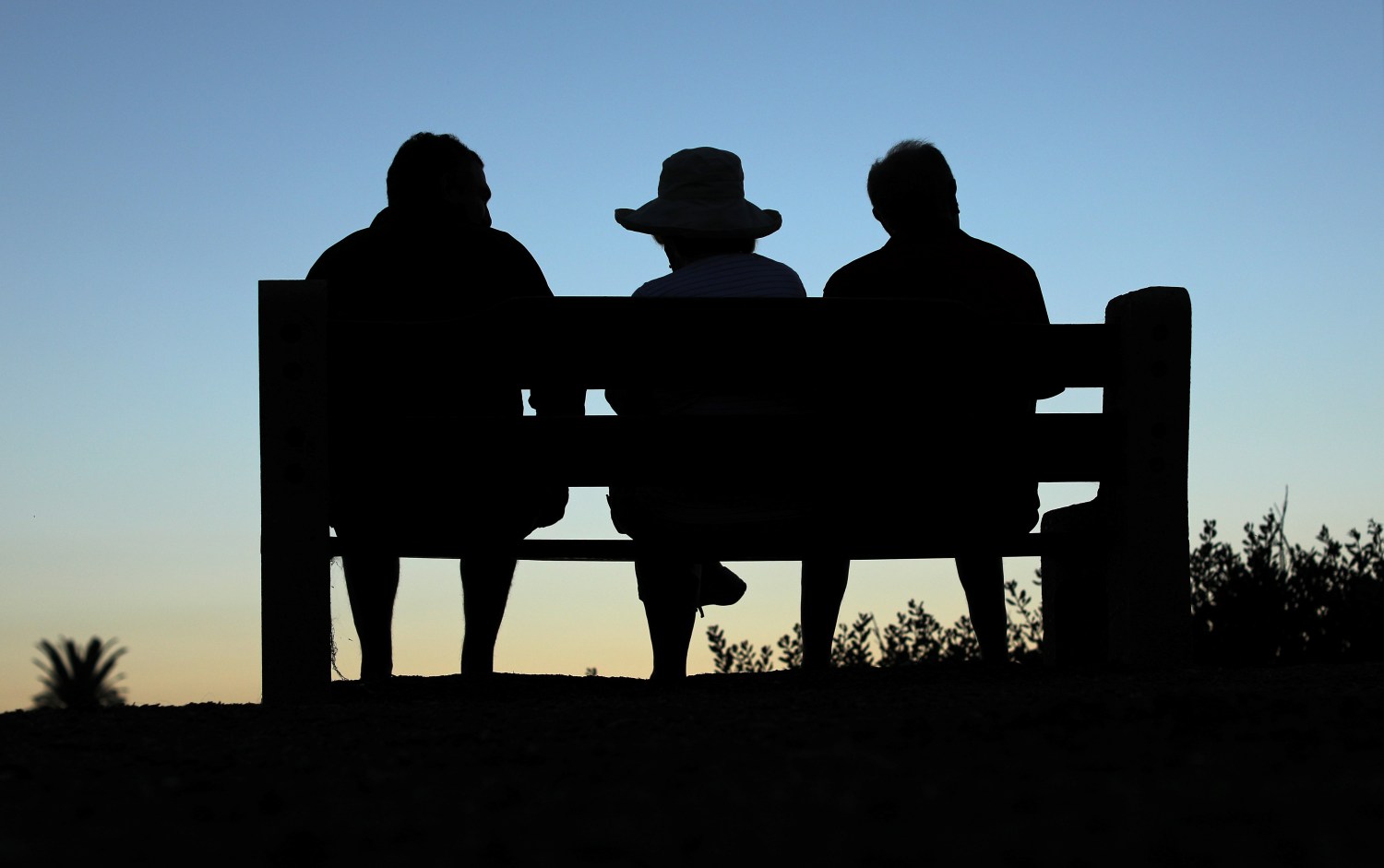 Elderly people sit on a park bench after sun set in Encinitas, California, U.S., July 5, 2017. Picture taken July 5, 2017. REUTERS/Mike Blake - RC1B80CC7FF0