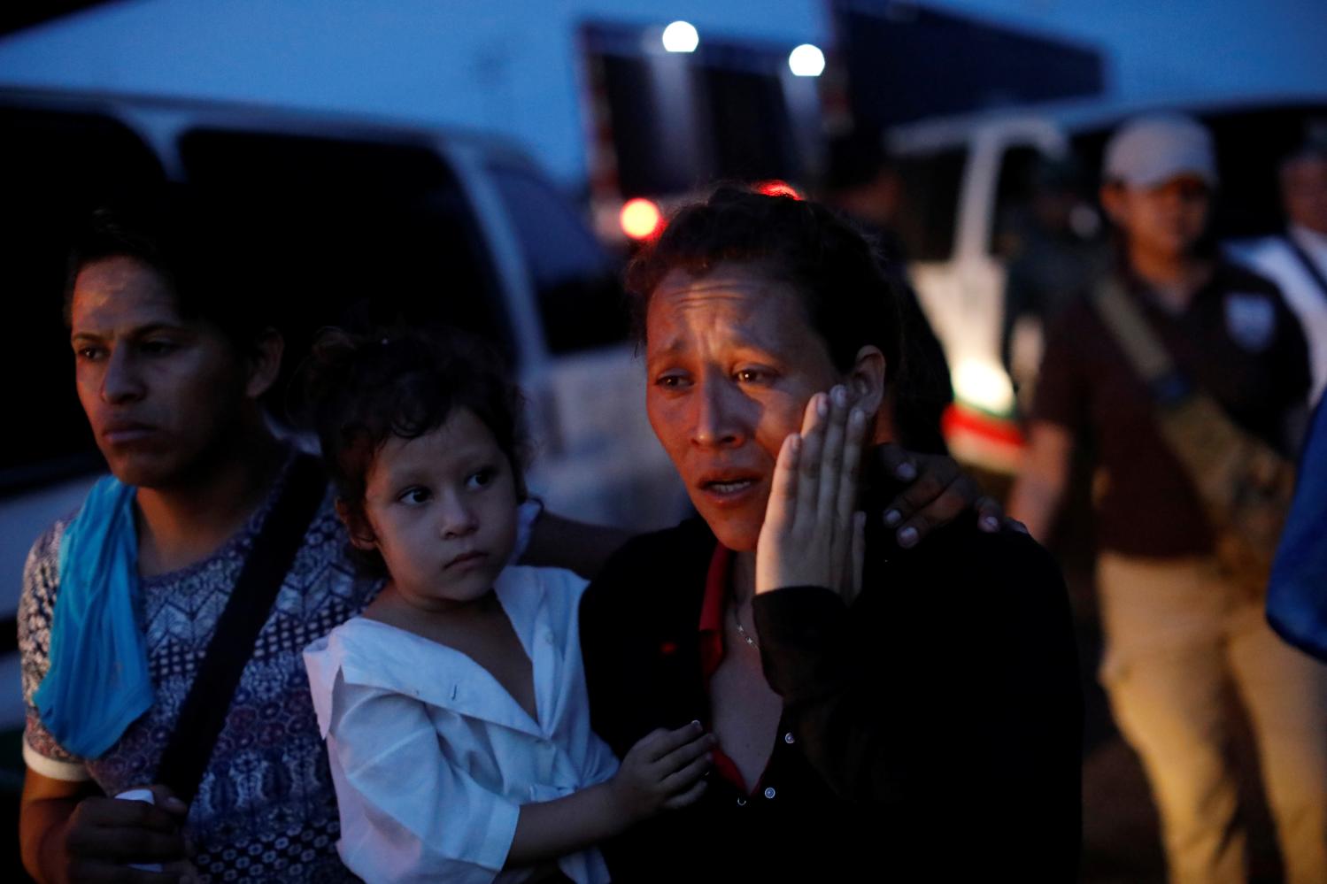 A woman, part of a convoy of Central American migrants, is escorted into a van by National Institute of Migration (INM) officers, after being detained at a checkpoint on the outskirts of Tapachula, Mexico, May 19, 2019. REUTERS/Andres Martinez Casares - RC1F10AAEE00