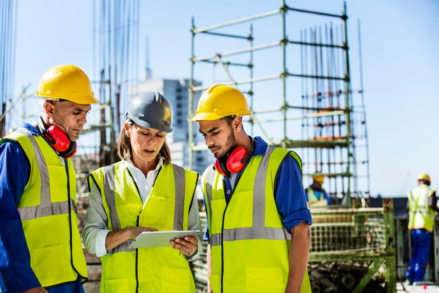 Male and female architects using digital tablet at construction site