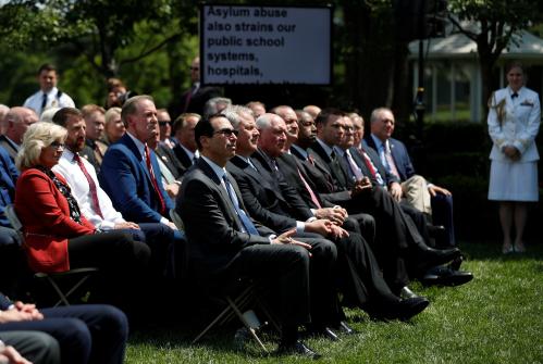 U.S. President Donald Trump's cabinet, including Treasury Secretary Steven Mnuchin, listen as he speaks about his administration's proposals to change U.S. immigration policy in the Rose Garden of the White House in Washington, U.S., May 16, 2019. REUTERS/Carlos Barria - RC19F80D2FD0