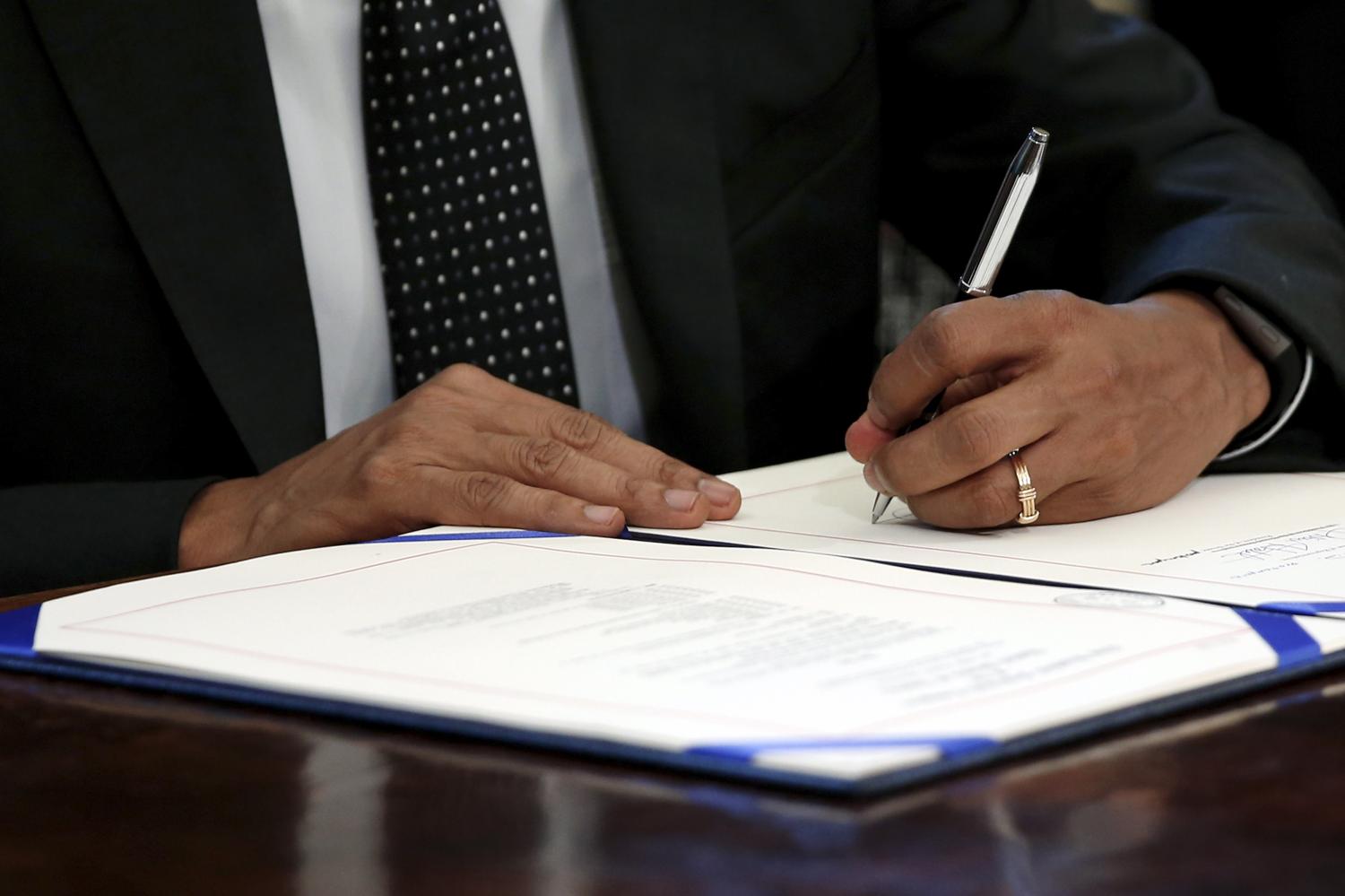 U.S. President Barack Obama signs the Sawtooth National Recreation Area and Jerry Peak Wilderness Additions Act into law at his desk in Oval Office at the White House in Washington August 7, 2015. The law sets aside 275,665 acres (1,116 square km) of Idaho's Boulder-White Clouds Wilderness to be permanently protected from development.  REUTERS/Jonathan Ernst - GF20000016915