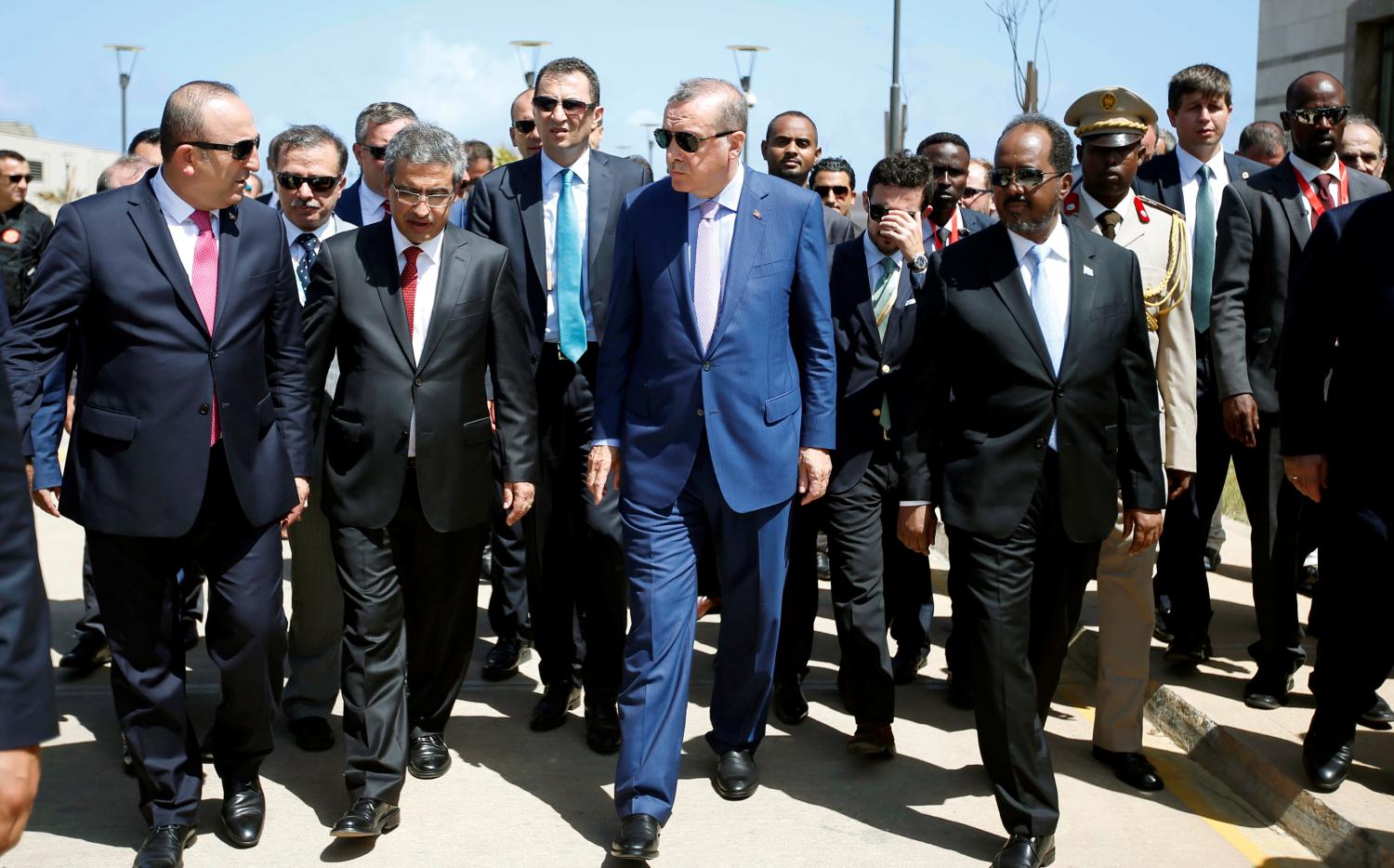 Turkish President Tayyip Erdogan (C) walks alongside Somalia's President Hassan Sheikh Mohamud (R) and other unidentified officials during the opening ceremony of the new Turkish embassy in Abdiazizi district of Somalia's capital Mogadishu, June 3, 2016. REUTERS/Feisal Omar - S1AETHUSPPAA