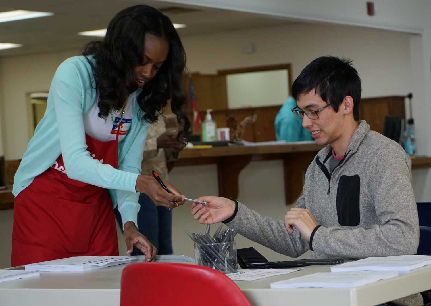 A voting official hands back an early voter his ID in Valdosta, Georgia, U.S., October 24, 2018. Photo taken October 24, 2018. REUTERS/Lawrence Bryant - RC1540DF0C50