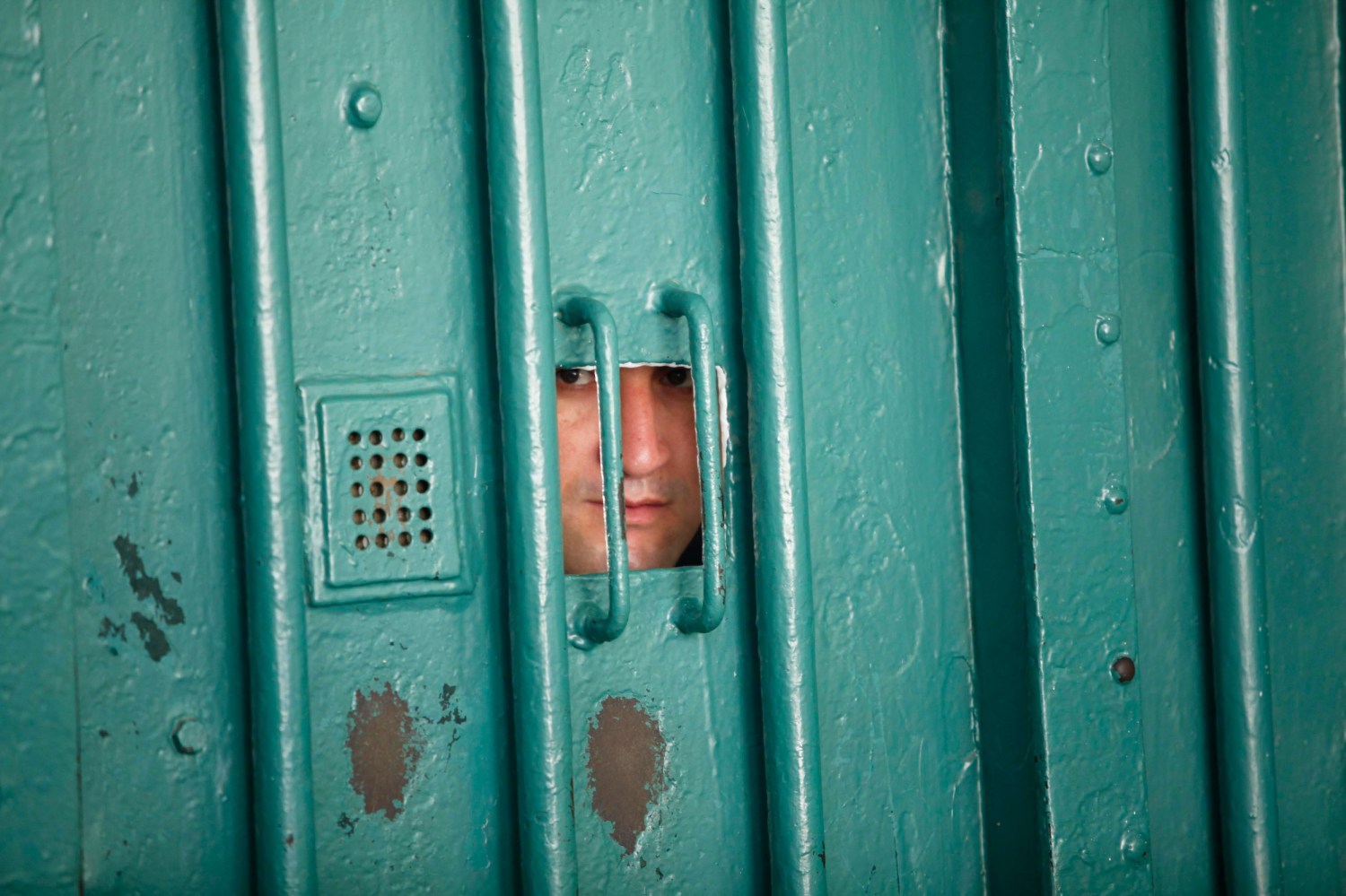 A prison guard looks through a small window at the El Harrach prison in Algiers July 14, 2010. Algeria is ready to open its prisons to international inspection to counter allegations that inmates are abused, Farouk Ksentini, chairman of the National Consultative Commission for the Promotion and Protection of Human Rights, a government-backed human rights body, said on Wednesday.       To match Interview ALGERIA-PRISONS/     REUTERS/Louafi Larbi (ALGERIA - Tags: CRIME LAW) - GM1E67F02LF01