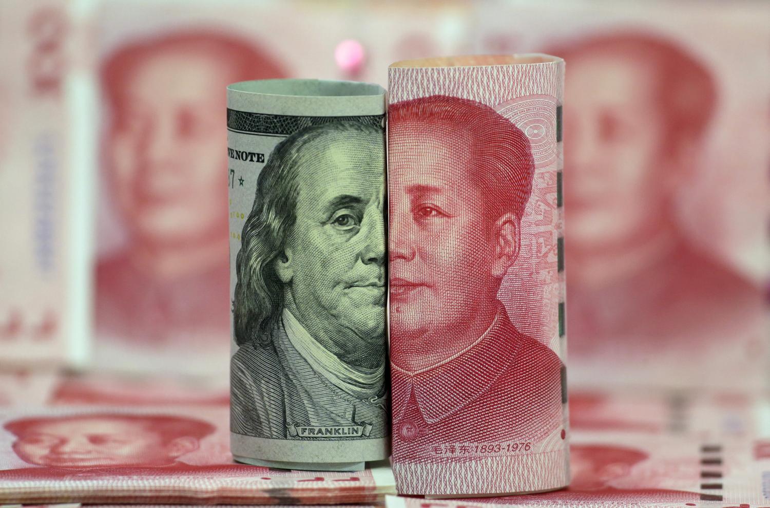 A Benjamin Franklin U.S. 100-dollar banknote and a Chinese 100-yuan banknote depicting the late Chinese Chairman Mao Zedong, are seen in a picture illustration in Beijing, China, January 21, 2016. REUTERS/Jason Lee - GF20000103031