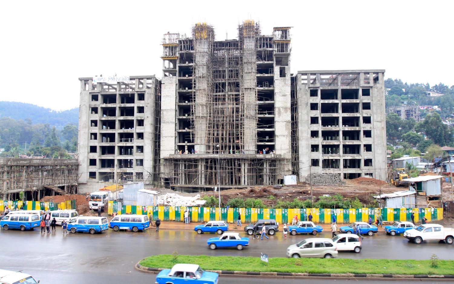 Traffic passes along a street with buildings under construction in Ethiopia's capital Addis Ababa, September 16, 2013. When global drinks giant Diageo bought a brewery in Ethiopia, it paid a premium for a stake in a barely tapped African market that in the 1980s had spectacularly failed to feed its own population. Ethiopia is now sub-Saharan Africa's fifth biggest economy, leap-frogging next door Kenya and wooing investors from Sweden, Britain and China, as other emerging markets lose some of their shine. Picture taken September 16, 2013. To match Insight ETHIOPIA-ECONOMY/  REUTERS/Tiksa Negeri (ETHIOPIA - Tags: POLITICS SOCIETY BUSINESS CONSTRUCTION) - GM1E99I040U01