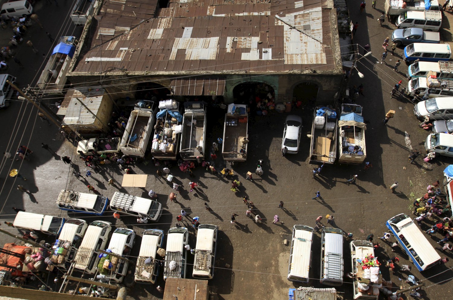 Trucks and commericial vehicles are unloaded at the Mercato market in Addis Ababa September 11, 2015. Addis Ababa's 'Mercato' - Italian for 'market' - is reputedly the biggest open-air market in Africa, lying in the west of the capital. Supermarkets have sprouted across the city as the metropolis has expanded with Ethiopia's booming economy, but Mercato remains a popular destination for shoppers seeking clothing, electronics and a huge range of other items. It has been around for as long as the city, which was founded at the end of the 19th century, but it took its current form, and its name, from the Italians who invaded Ethiopia in 1935. The Italian occupation ended in 1941. Picture taken September 11, 2015.    REUTERS/Tiksa Negeri - GF10000267939