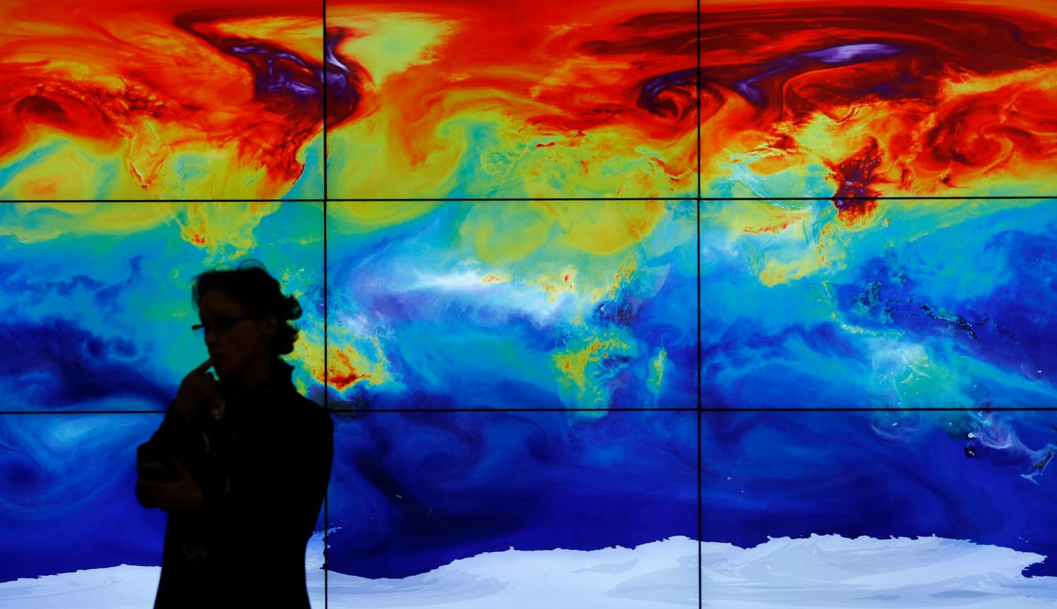 A participant is pictured in front of a screen projecting a world map during the World Climate Change Conference 2015 (COP21) at Le Bourget, near Paris, France, December 8, 2015. REUTERS/Stephane Mahe  - LR1EBC80Y0ORX