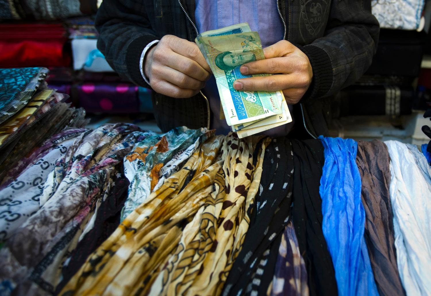 EDITORS' NOTE: Reuters and other foreign media are subject to Iranian restrictions on leaving the office to report, film or take pictures in Tehran.A shopkeeper counts Iranian bank notes at his shop in a bazar in Tehran February 25, 2012. REUTERS/Raheb Homavandi (IRAN - Tags: SOCIETY BUSINESS) - GM1E82Q02H301