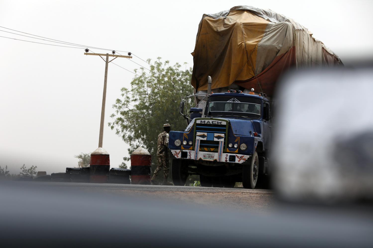 A soldier checks a truck loaded with goods at a military check point in Dapchi, Yobe state, Nigeria February 27, 2018. REUTERS/Afolabi Sotunde - RC19251521B0