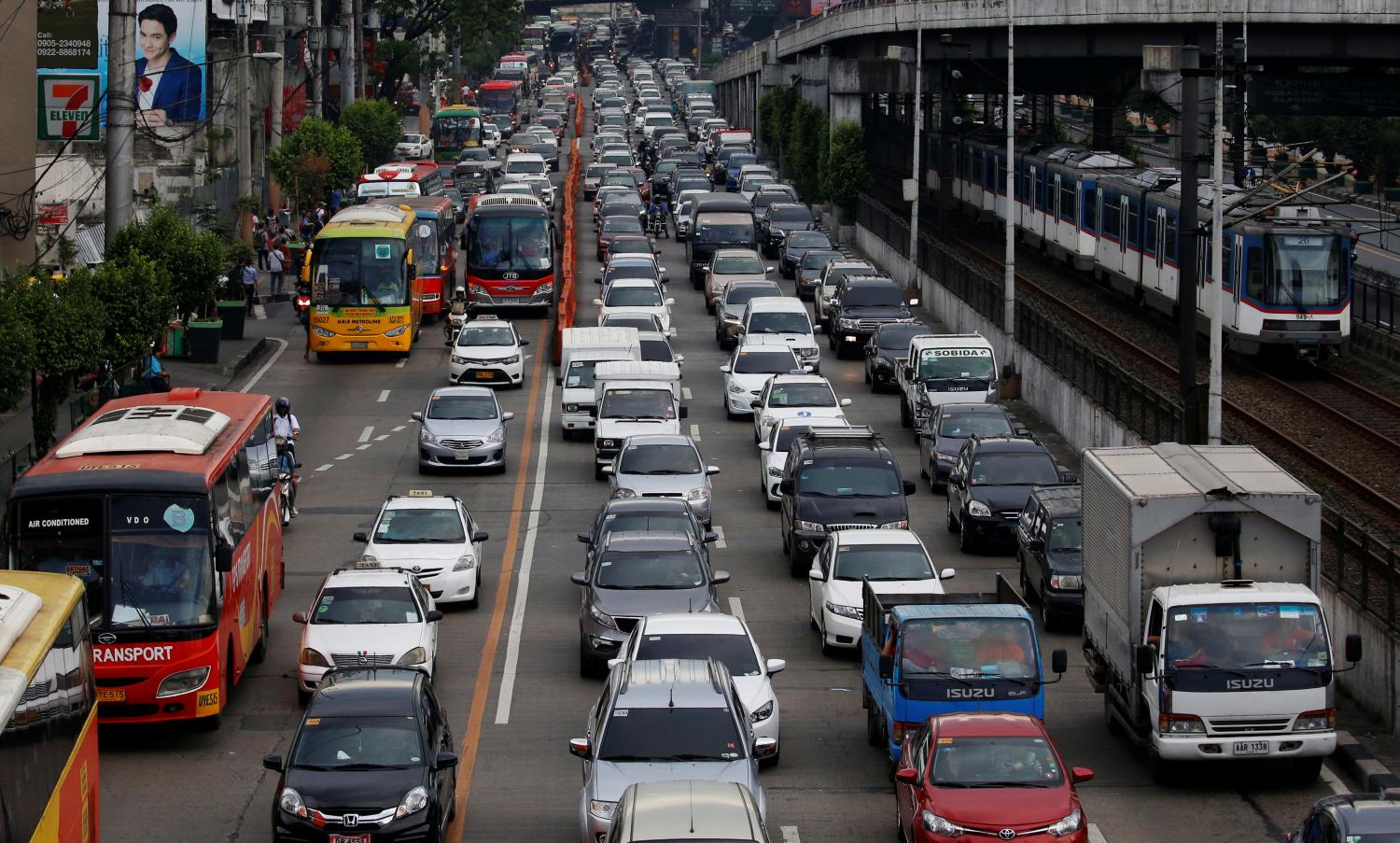 Motorists drive through a heavy traffic flow near a passing metro train along the main highway EDSA in Makati, Metro Manila, Philippines June 21, 2016. REUTERS/Erik De Castro - D1BETLELWXAA