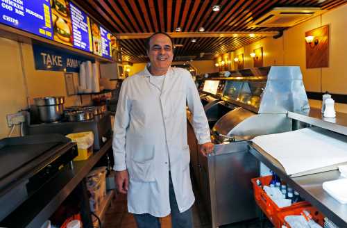 Paul Georgiou, owner of The Dining Plaice fish and chip shop, poses for a photograph in central London May 22, 2012. Deep-fried fish in a crispy batter with fat golden chips is still as popular as ever with the British public, ranked alongside roast beef, Yorkshire pudding and chicken tikka masala as the nation's favourite dish. Picture taken May 22, 2012. REUTERS/Eddie Keogh (BRITAIN - Tags: FOOD SOCIETY) ATTENTION EDITORS: PICTURE 12 OF 29 FOR PACKAGE 'AS BRITISH AS FISH AND CHIPS'.SEARCH 'EDDIE FISH' TO FIND ALL IMAGES - GM1E8671J3U01