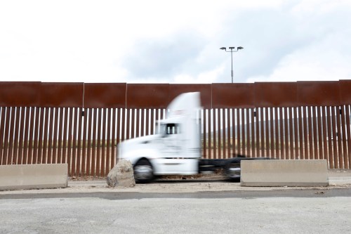 A truck drives next to the border fence while waiting in a long queue for border customs control to cross into the U.S., at the Otay border crossing in Tijuana, Mexico April 4, 2019. REUTERS/Carlos Jasso - RC12300AE540
