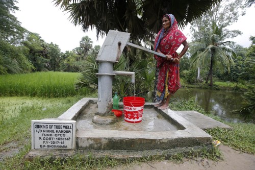 A woman uses a hand pump to collect drinking water on Ghoramara Island, India, September  22, 2018. Picture taken on September 22, 2018. REUTERS/Rupak De Chowdhuri - RC138069BE00