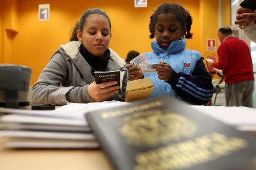 Immigrants hold passports and residence permits at an immigration office in Granada January 26, 2010. The government once spoke of how immigration could increase Spain's population by 50 percent to 66 million. Now unemployment is around 18 percent -- and 10 percentage points higher among foreign workers -- it is changing its tune. It has drastically cut back on working visas, tightened rules on family reunification and offered money to migrants wanting to leave Spain. To match feature SPAIN-IMMIGRANTS/    REUTERS/Pepe Marin (SPAIN - Tags: SOCIETY BUSINESS) - GM1E62N0MOX01