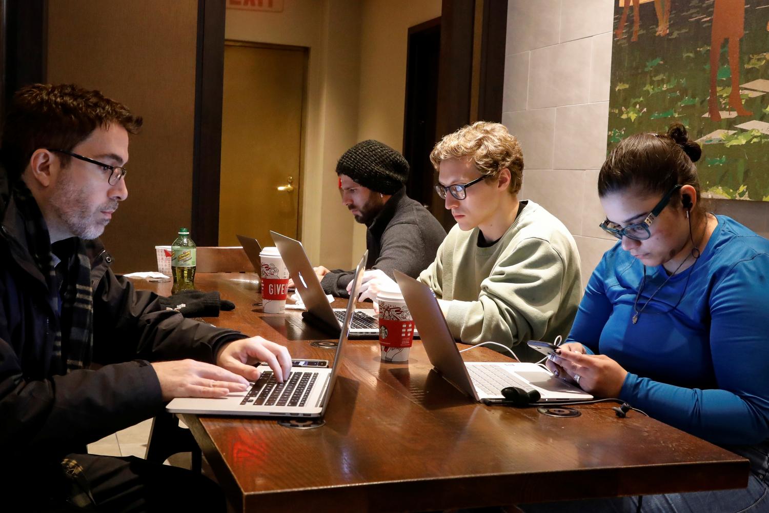 Customers use the internet at a Starbucks in the financial district in New York City, U.S., December 14, 2017. REUTERS/Brendan McDermid - RC174920FF60