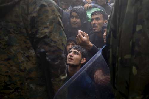 Migrants and refugees beg Macedonian policemen to allow passage to cross the border from Greece into Macedonia during a rainstorm, near the Greek village of Idomeni, September 10, 2015. Reuters and The New York Times shared the Pulitzer Prize for breaking news photography for images of the migrant crisis in Europe and the Middle East. REUTERS/Yannis Behrakis      TPX IMAGES OF THE DAY      - GF10000387306