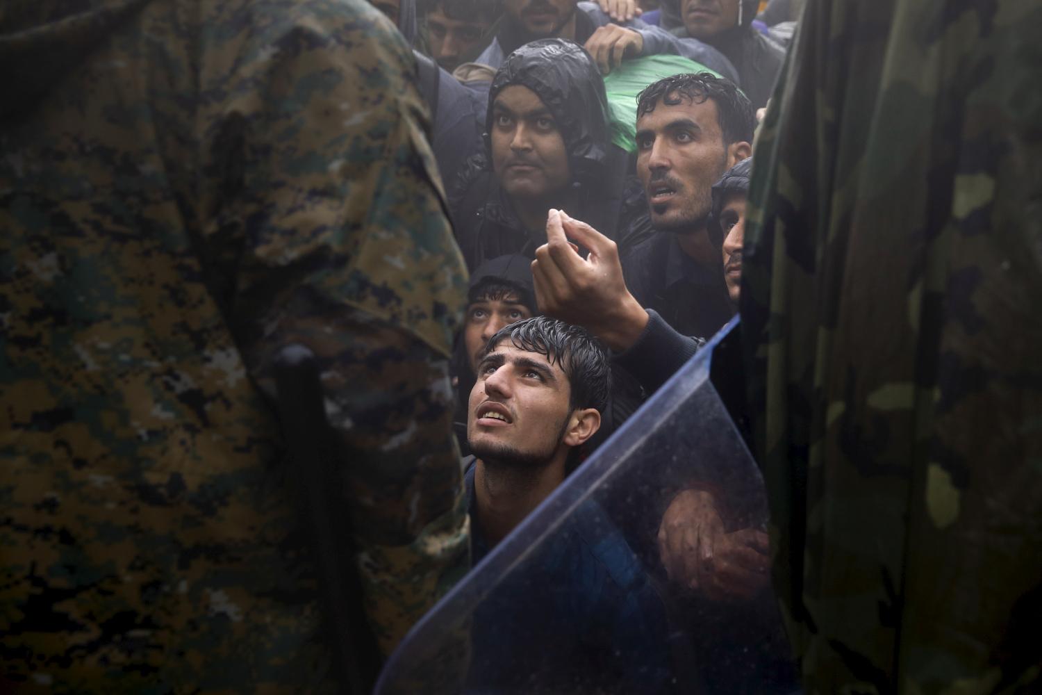 Migrants and refugees beg Macedonian policemen to allow passage to cross the border from Greece into Macedonia during a rainstorm, near the Greek village of Idomeni, September 10, 2015. Reuters and The New York Times shared the Pulitzer Prize for breaking news photography for images of the migrant crisis in Europe and the Middle East. REUTERS/Yannis Behrakis      TPX IMAGES OF THE DAY      - GF10000387306