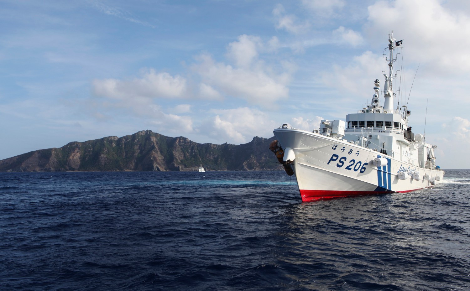 Japan Coast Guard vessel PS206 Houou sails in front of Uotsuri island, one of the disputed islands, called Senkaku in Japan and Diaoyu in China, in the East China Sea August 18, 2013. Boats carrying about 20 members of a Japanese nationalist group headed back to port on Sunday after sailing near tiny islands in the East China Sea that are at the centre of a dispute between Japan and China. The boats ships were surrounded by about 10 Japanese coast guard vessels when they approached within 1 nautical mile of the islands on Sunday morning. Coast guard crews in rubber boats urged them to leave through loudspeakers. REUTERS/Ruairidh Villar (JAPAN - Tags: MARITIME POLITICS) - GM1E98I1MSV01