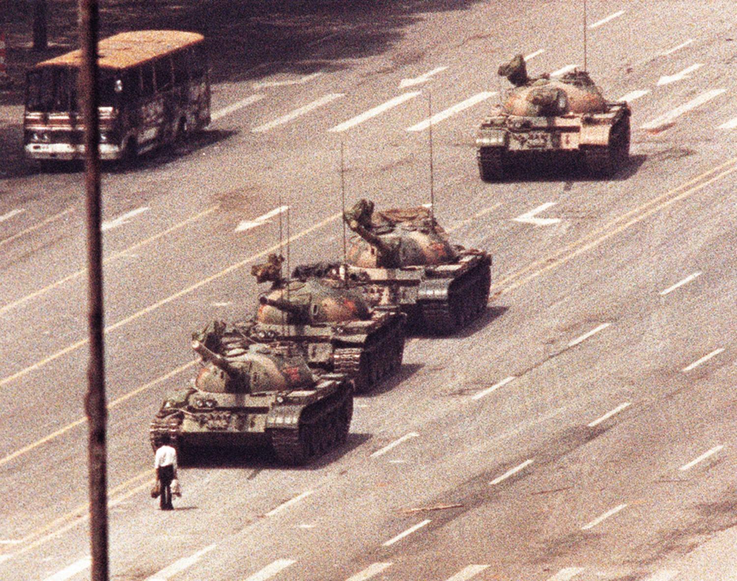 A man stands in front of a convoy of tanks in the Avenue of EternalPeace in Beijing, June 5, 1989. REUTERS/Arthur TsangAS - RP3DRIJQLTAA
