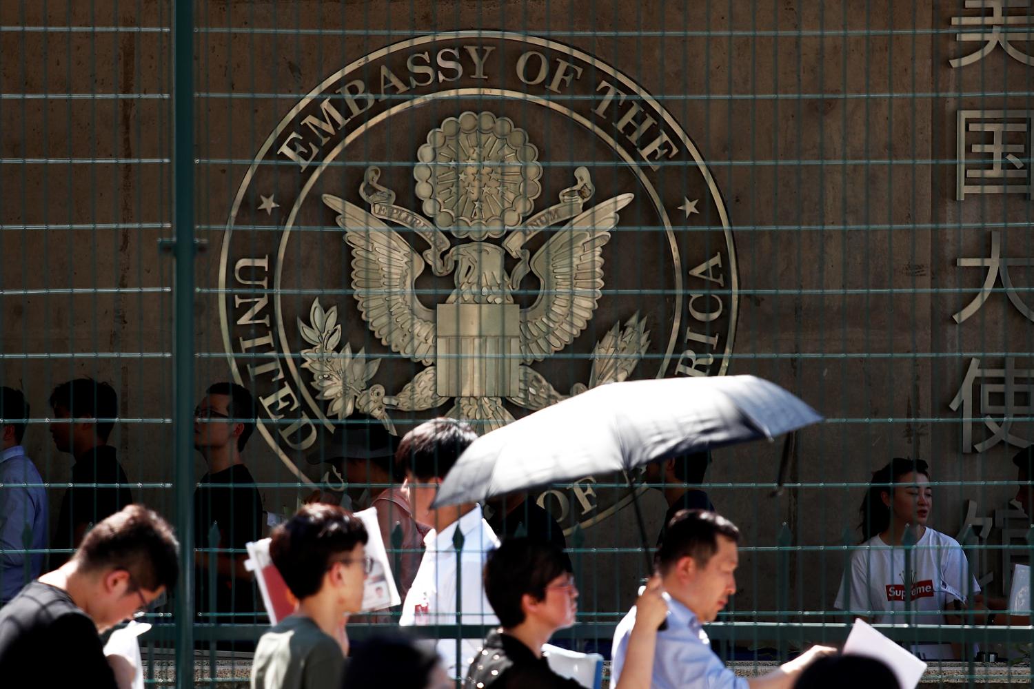 People wait outside the U.S. embassy, near the site of a blast in Beijing, China July 26, 2018. REUTERS/Damir Sagolj - RC19516BE290