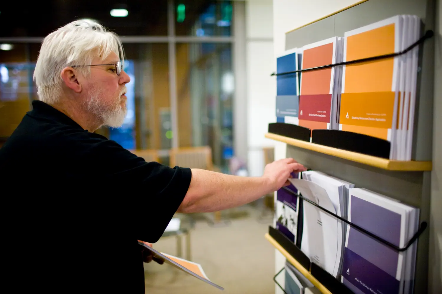 California state worker Curtis Walker looks over retirement plan brochures at the Calpers regional office in Sacramento, California October 21, 2009. Calpers, the largest U.S. public pension fund, manages retirement benefits for more than 1.6 million people, with assets comparable in value to the entire GDP of Israel. The Calpers investment portfolio had a historic drop in value, going from a peak of $250 billion in the fall of 2007 to $167 billion in March 2009, a loss of about a third during that period. It is now around $200 billion. REUTERS/Max Whittaker   (UNITED STATES BUSINESS) - WASE5AM03UX01