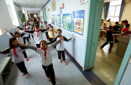 Primary school students do exercises in the corridor and in a classroom as they avoid outdoor activities due to heavy smog, in Beijing October 11, 2014. The Beijing Meteorological Bureau forecast that gales brought by a cold spell is expected to arrive at the Chinese capital on Saturday night, which would disperse severe smog and air pollution shrouding China's northern regions since Wednesday, Xinhua News Agency reported. REUTERS/Stringer (CHINA - Tags: ENVIRONMENT SOCIETY EDUCATION) CHINA OUT. NO COMMERCIAL OR EDITORIAL SALES IN CHINA - GM1EAAB1CVT01