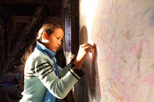 A girl writes with chalk while celebrating Shreepanchami festival at a temple in Kathmandu February 8, 2011. Children are given their first writing and reading lessons at the temple during this festival in the belief that the goddess of education Saraswati will help them excel in education. REUTERS/Navesh Chitrakar (NEPAL - Tags: EDUCATION SOCIETY) - GM1E7280ZZG01