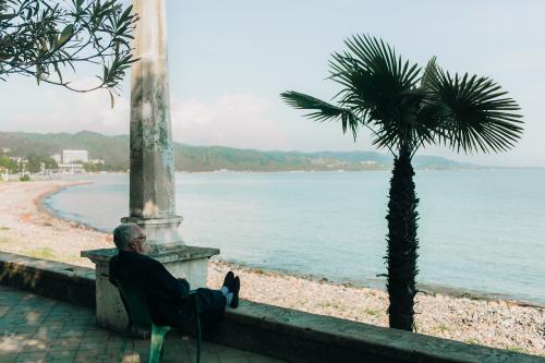 old man sitting at the beach