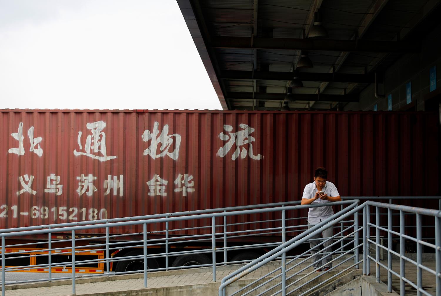 A truck driver waits at a logistics area of the Shanghai Free Trade Zone, in Shanghai.
