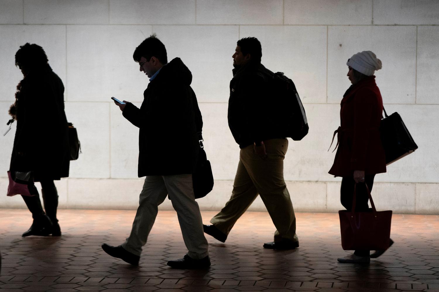 Commuters walk from the Federal Triangle Metro station after the U.S. government reopened with about 800,000 federal workers returning after a 35-day shutdown in Washington, U.S., January 28, 2019.  REUTERS/Joshua Roberts - RC1B387042D0