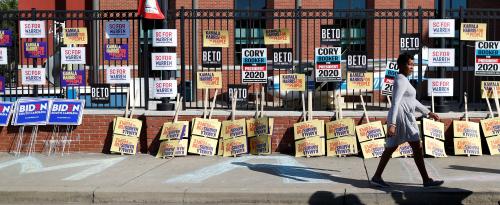 A woman walks past a variety of campaign banners for Democratic presidential candidates at the entrance of "Jim Clyburn's World Famous Fish Fry" in Columbia, South Carolina, U.S., June 21, 2019.  REUTERS/Randall Hill - RC17A8C3A840