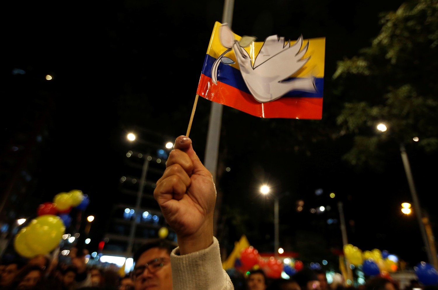 A man holds a Colombian flag after Colombia's government and Revolutionary Armed Forces of Colombia (FARC) rebels reached a final peace deal on Wednesday to end a five-decade war, in Bogota, Colombia, August 24, 2016. REUTERS/John Vizcaino - S1BETXJWAEAB
