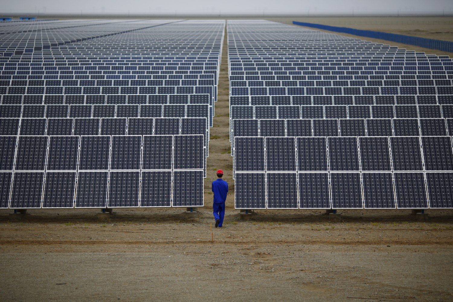 A worker inspects solar panels at a solar Dunhuang, 950km (590 miles) northwest of Lanzhou, Gansu Province September 16, 2013. China is pumping investment into wind power, which is more cost-competitive than solar energy and partly able to compete with coal and gas. China is the world's biggest producer of CO2 emissions, but is also the world's leading generator of renewable electricity. Environmental issues will be under the spotlight during a working group of the Intergovernmental Panel on Climate Change, which will meet in Stockholm from September 23-26. REUTERS/Carlos Barria    BEST QUALITY AVAILABLE - GF20000056392
