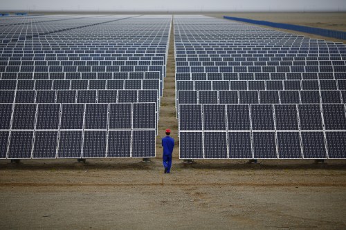 A worker inspects solar panels at a solar Dunhuang, 950km (590 miles) northwest of Lanzhou, Gansu Province September 16, 2013. China is pumping investment into wind power, which is more cost-competitive than solar energy and partly able to compete with coal and gas. China is the world's biggest producer of CO2 emissions, but is also the world's leading generator of renewable electricity. Environmental issues will be under the spotlight during a working group of the Intergovernmental Panel on Climate Change, which will meet in Stockholm from September 23-26. REUTERS/Carlos Barria    BEST QUALITY AVAILABLE - GF20000056392