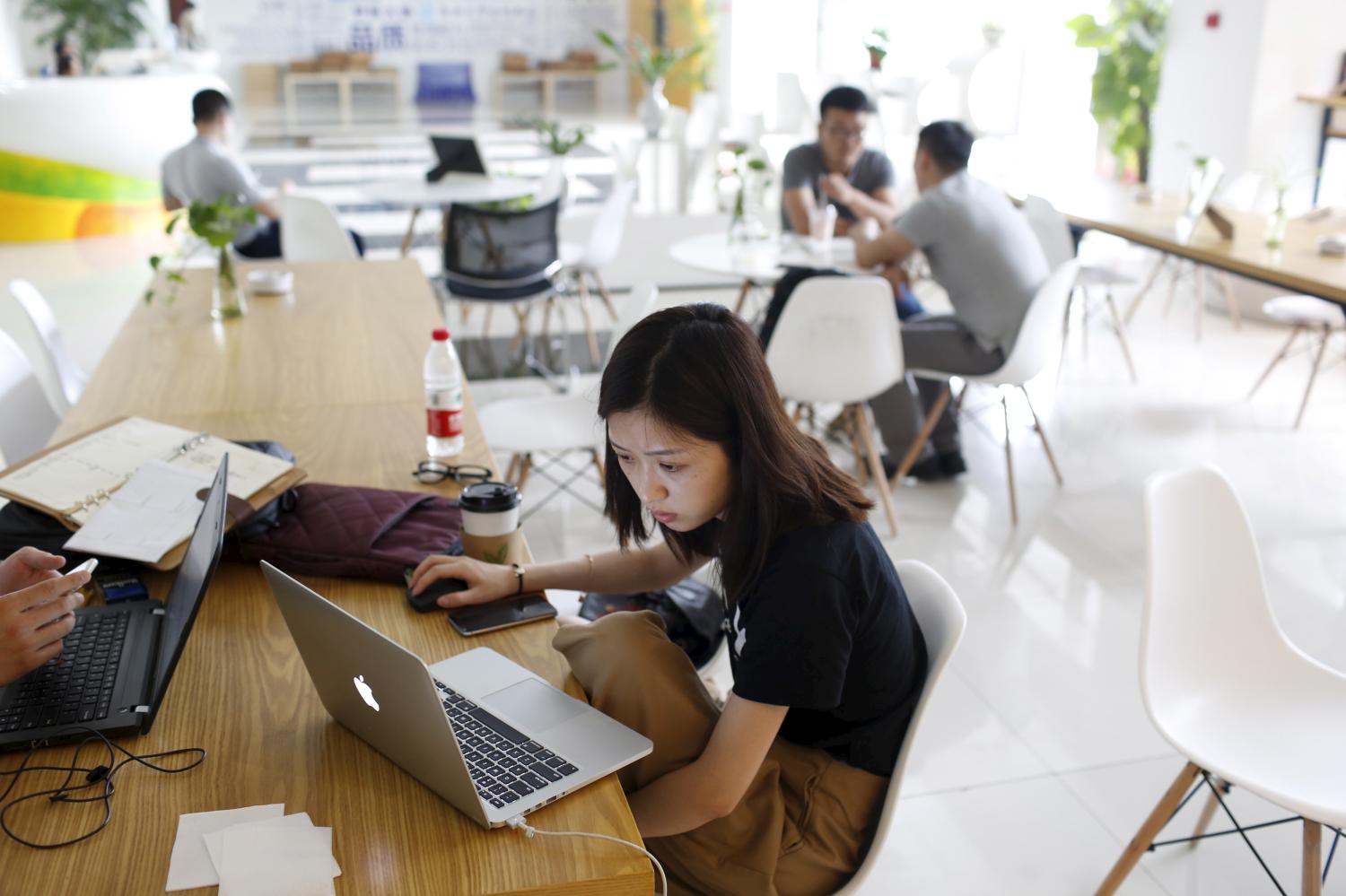 Young entrepreneurs look at their computers at a resting area inside the University Students Venture Park, in Shanghai, China, July 29, 2015. The University Students Venture Park in northern Shanghai was designed as an incubator for college students considering a startup. The lobby is decked out in a sunny palette and garnished with inspiring slogans about creativity; outside a large sign reads "Dream Community". Picture taken July 29, 2015.  To match INSIGHT CHINA-ENTREPRENEURS/   REUTERS/Aly Song - GF10000241676