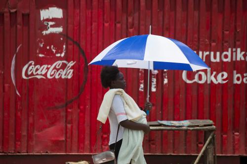 A woman walks by a store decorated with a Coca-Cola logo in the town of Ahero near Kisumu, Kenya April 20, 2017. REUTERS/Baz Ratner - RC1E52E26840