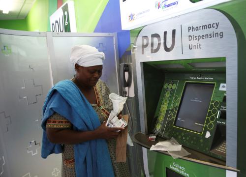 Rebecca Palai withdraws her medication at an ATM pharmacy which allows patients with chronic illnesses to receive repeat medication within three minutes, in Alexander township, South Africa, March 15, 2018. REUTERS/Siphiwe Sibeko - RC1C011CB2B0