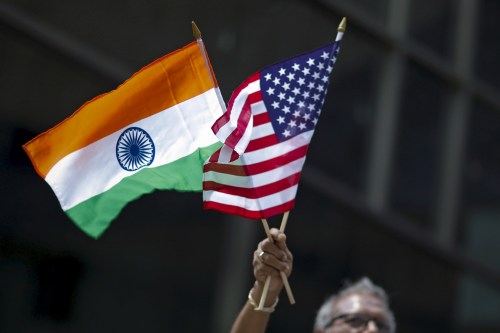 A man holds the flags of India and the U.S. while people take part in the 35th India Day Parade in New York August 16, 2015. REUTERS/Eduardo Munoz - GF20000022053