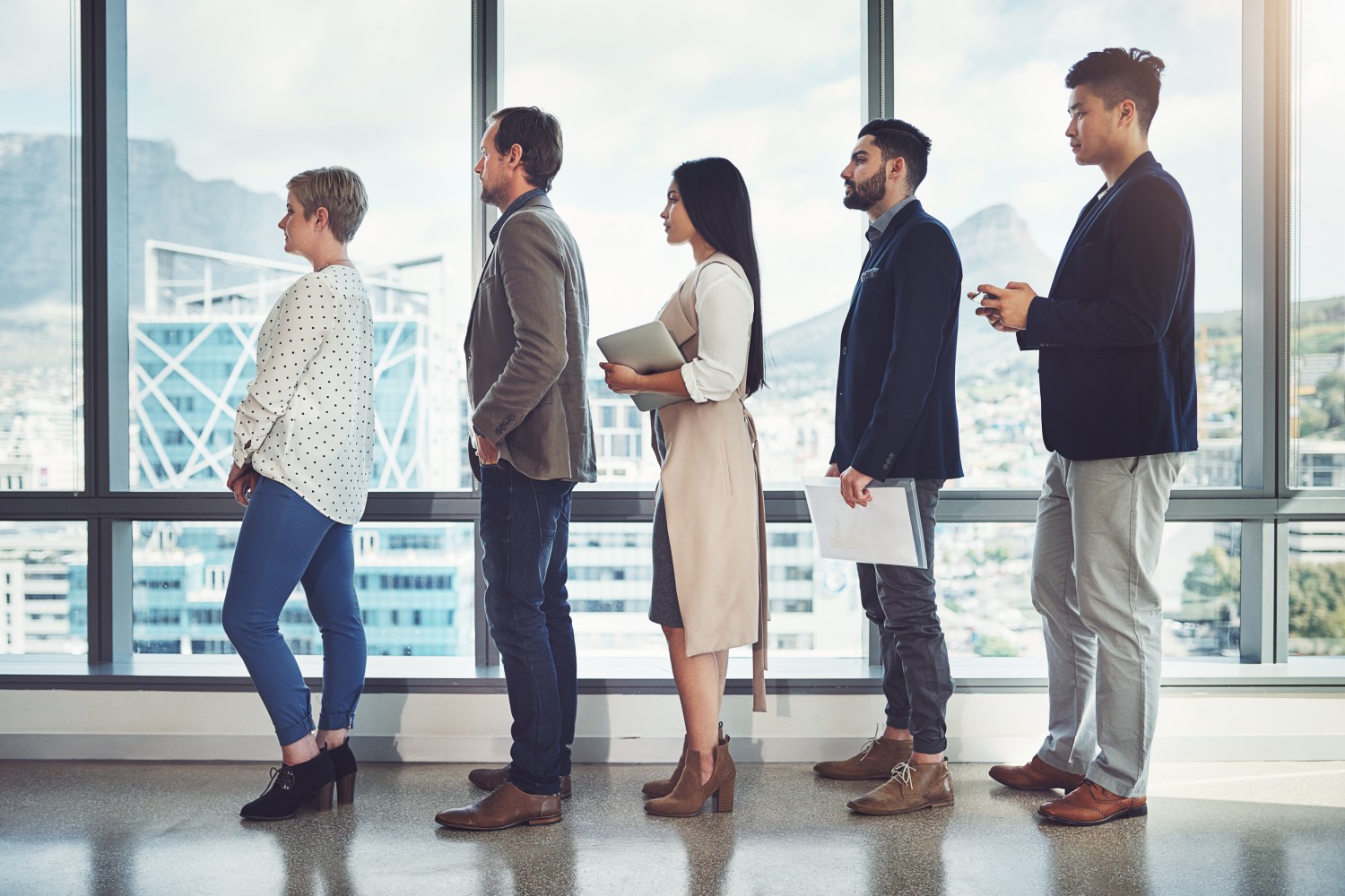 Shot of a group of businesspeople standing in line in an office