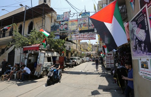 A boy rides on a motorbike as he drives past Palestinian flags at Burj al-Barajneh refugee camp in Beirut, Lebanon, June 24, 2019.  REUTERS/Aziz Taher - RC1896B964D0