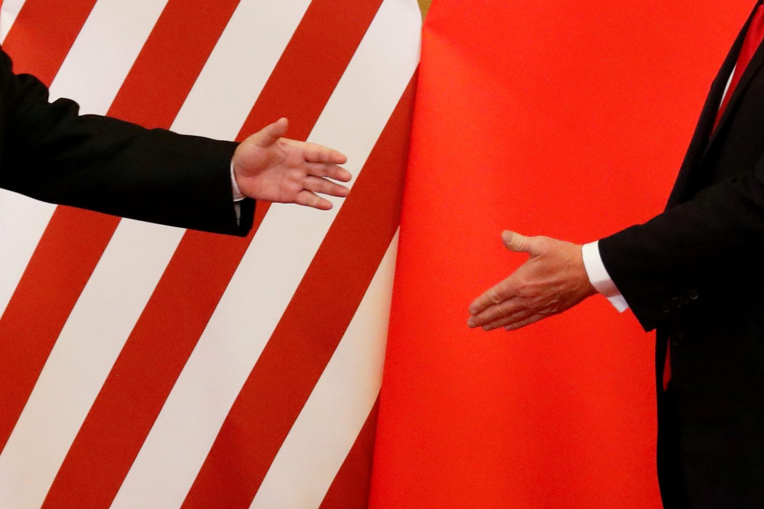 U.S. President Donald Trump and China's President Xi Jinping shake hands after making joint statements at the Great Hall of the People in Beijing, China, November 9, 2017. Damir Sagolj: "It's one of those "how to make a better or at least different shot when two presidents shake hands several times a day, several days in row". If I'm not mistaken in calculation, presidents Xi Jinping of China and Donald Trump of the U.S. shook their hands at least six times in events I covered during Trump's recent visit to China. I would imagine there were some more handshakes I haven't seen but other photographers did. And they all look similar - two big men, smiling and heartily greeting each other until everyone gets their shot. But then there is always something that can make it special - in this case the background made of U.S. and Chinese flags. They shook hands twice in front of it, and the first time it didn't work for me. The second time I positioned myself lower and centrally, and used the longest lens I have to capture only hands reaching for a handshake." REUTERS/Damir Sagolj/File Photo  SEARCH "POY TRUMP" FOR THIS STORY. SEARCH "REUTERS POY" FOR ALL BEST OF 2017 PACKAGES.    TPX IMAGES OF THE DAY - RC1B1E5EF340