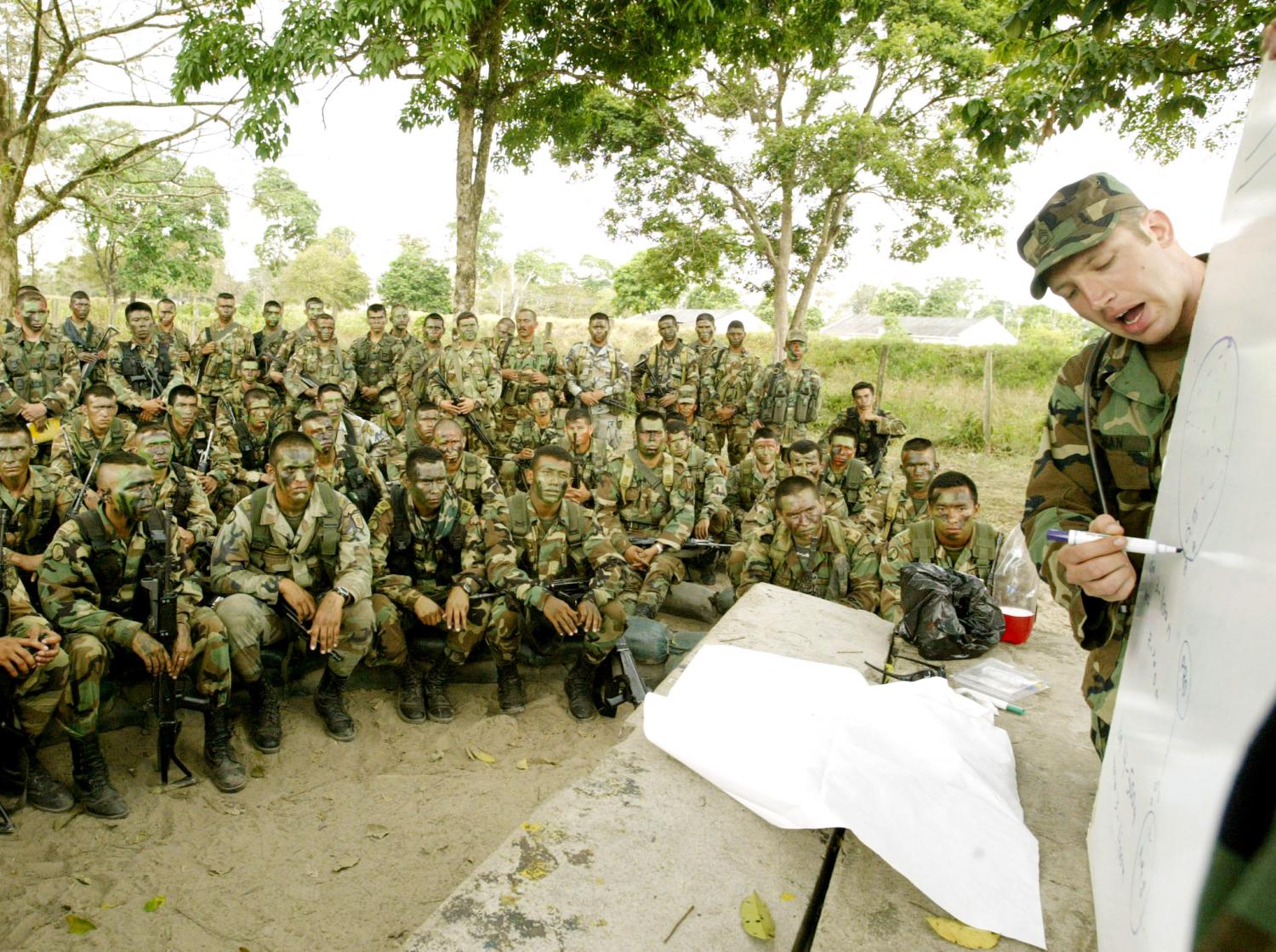 A U.S. Special Forces soldier talks to Colombian soldiers at a militarybase during training in Saravena, Arauca province, February 7, 2003. Atleast 70 U.S. soldiers are in Saravena training Colombian army troopsto combat leftist rebels. REUTERS/Eliana AponteEA/ME - RP3DRINWHOAA