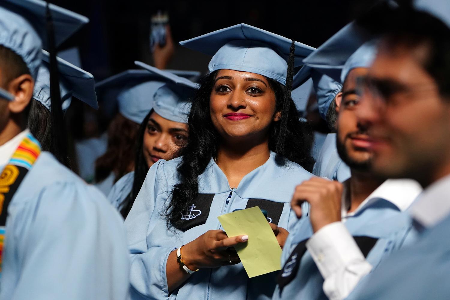 A student looks at the crowd during commencement at the Mailman School of Public Health at Columbia University in the Manhattan borough of New York, New York, U.S., May 21, 2019. REUTERS/Carlo Allegri - RC15A141E400
