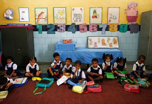 Schoolgirls eat their free mid-day meal, distributed by a government-run primary school, in New Delhi July 5, 2013. In an incident on July 16, 2013, twenty-five Indian children from a school in Mashrakh village in the district of Chapra died and dozens needed hospital treatment after apparently being poisoned by a school meal, provided under the Mid-Day Meal Scheme, sparking violent protests and angry allegations of blame. Neither the children nor the school pictured in this photograph were involved in Tuesday's poisoning incident. ATTENTION EDITORS - Neither the children nor the school pictured in this photograph were involved in Tuesday's poisoning incident. Picture taken July 5, 2013. REUTERS/Mansi Thapliyal (INDIA - Tags: FOOD EDUCATION SOCIETY) - GM1E97I0U8R01