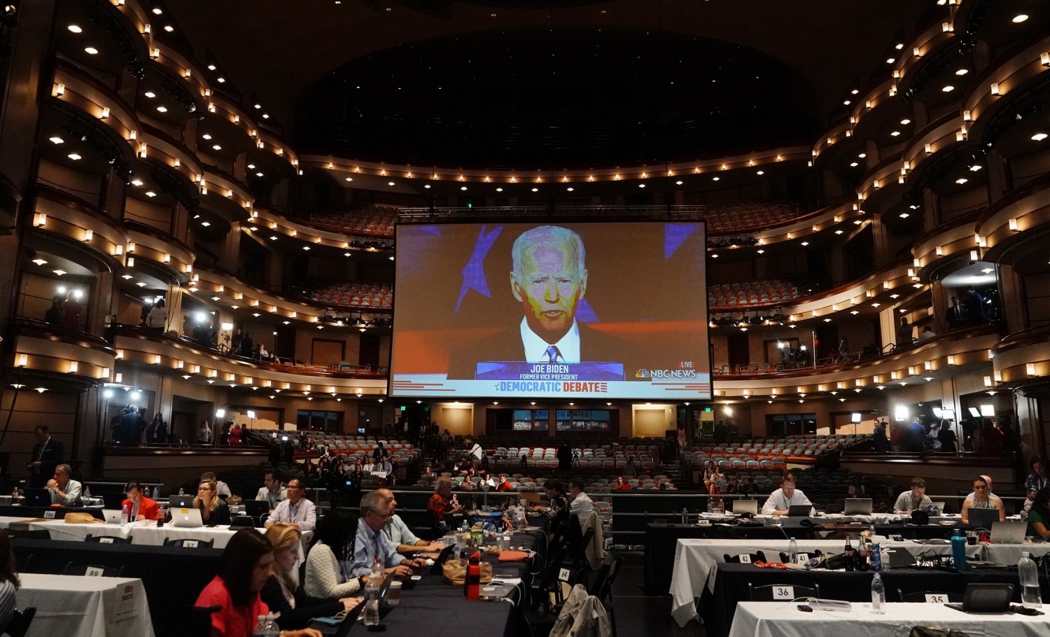 Former Vice President Joe Biden is seen on a live video feed inside a concert hall of the Adrienne Arsht Performing Arts Center being used as a media filing center during the second night of the first U.S. 2020 presidential election Democratic candidates debate in Miami, Florida, U.S., June 27, 2019. REUTERS/Carlo Allegri - HP1EF6S0AOWLW