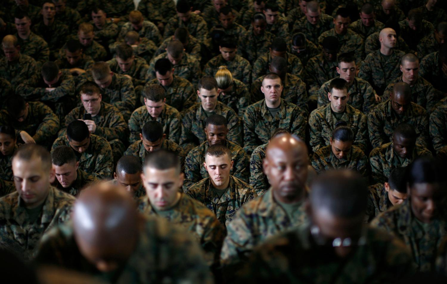 U.S. Marines bow their heads in prayer before the arrival of President Barack Obama at Camp Lejeune, North Carolina, February 27, 2009.    REUTERS/Jim Young    (UNITED STATES) - GM1E52S08XG01