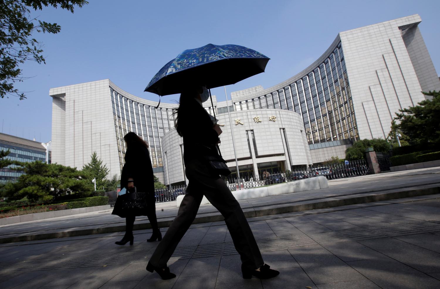 People walk past the headquarters of the People's Bank of China (PBOC), the central bank, in Beijing, China September 28, 2018. REUTERS/Jason Lee - RC15E2478890