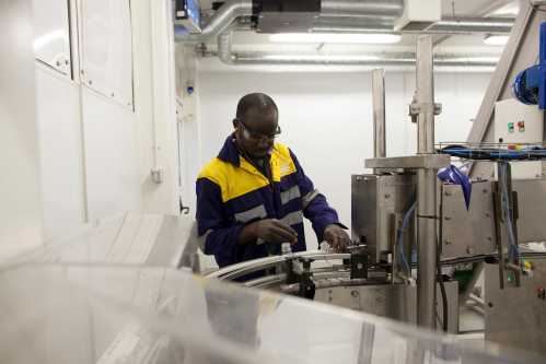 A technician inspects newly moulded bottles at the Guinness pop-up plant in Accra, July 2, 2014. Picture taken July 2, 2014.  To match Insight CONSUMERS-MANUFACTURERS/AFRICA    REUTERS/Francis Kokoroko (GHANA - Tags: BUSINESS) - GM1EA7411EN01
